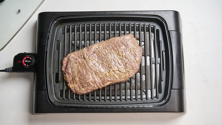 grilling steak on a grill