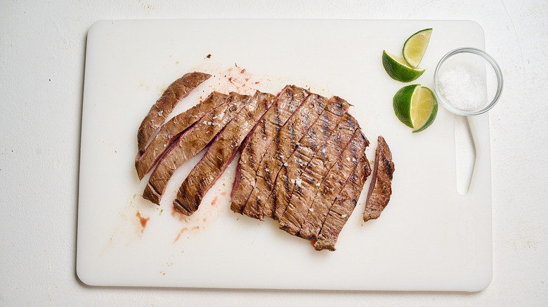 slicing steak on a cutting board