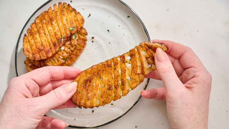 sliced potato being stretched with hands