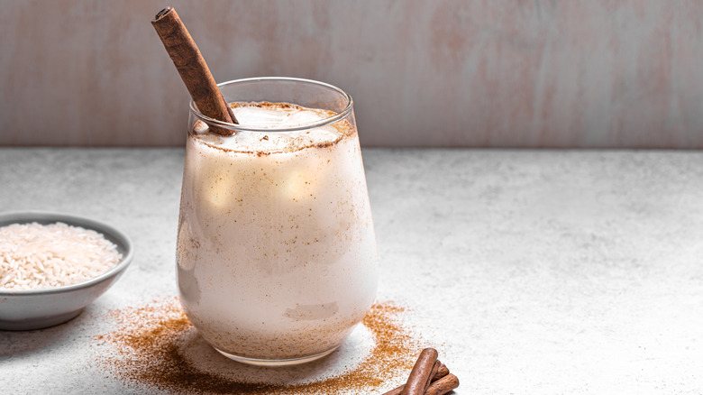 Glass of horchata with ice and a cinnamon stick
