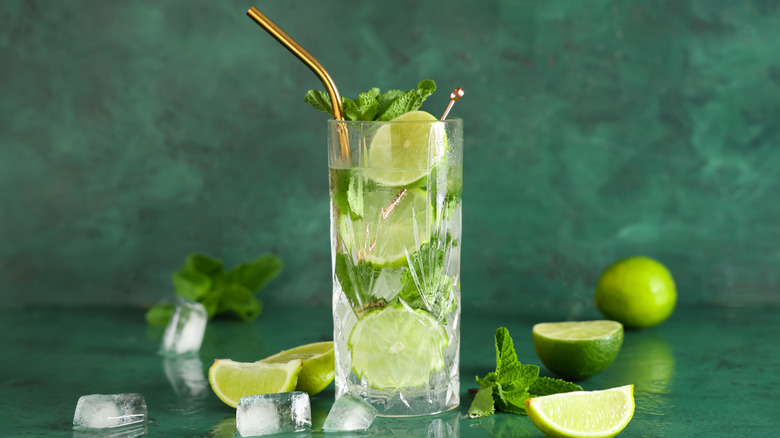 Mojito cocktail full of lime slices, mint leaves, and ice