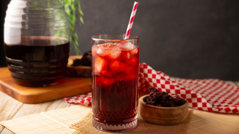 Agua de jamaica on wooden table with straw