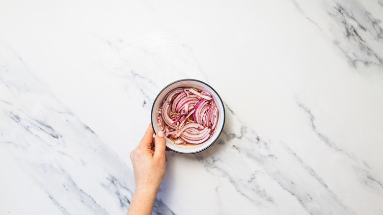 Onions in pickling liquid in bowl.