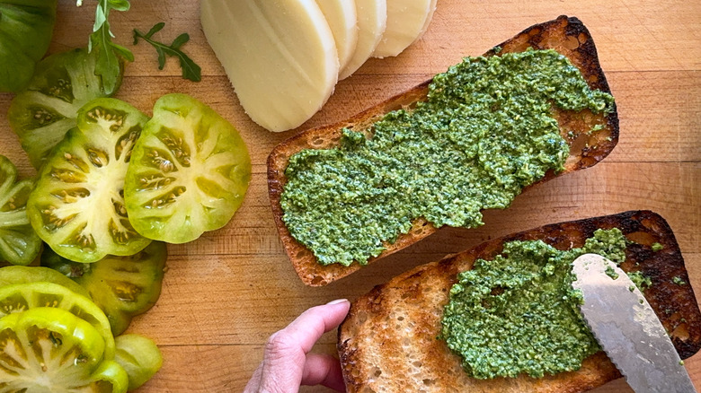 spreading pesto on bread