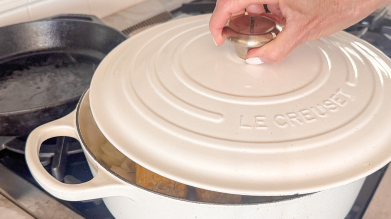 hand covering pot with lid