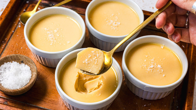 Spooning caramel panna cotta from white ramekin