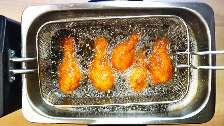 pieces of chicken in a fryer