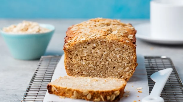 Healthy vegan oat and coconut loaf bread, cake on a cooling rack Grey stone background