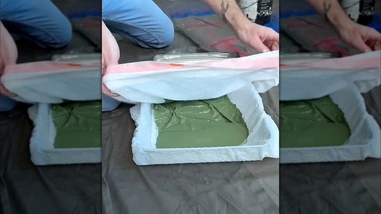 Bag covering paint tray with green paint on top
