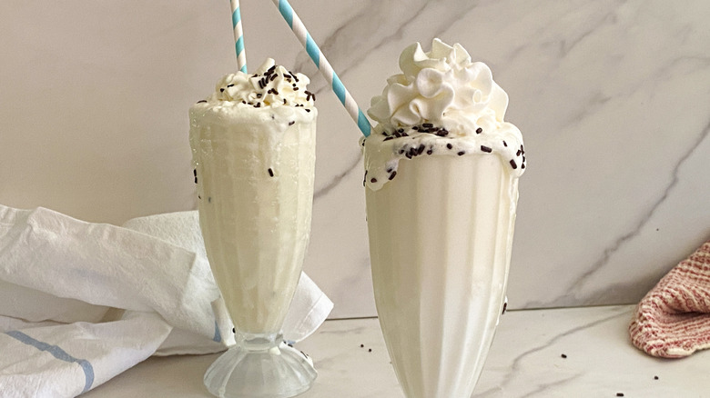 Vanilla milkshakes with sprinkles, whipped cream, and straws