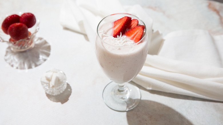 Smoothie garnished with coconut and strawberries