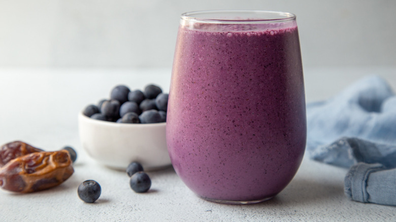 Blueberry smoothie in front of bowl of blueberries