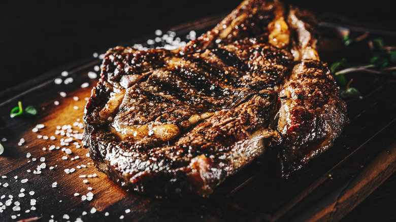 Grilled cowboy steak on a wooden cutting board