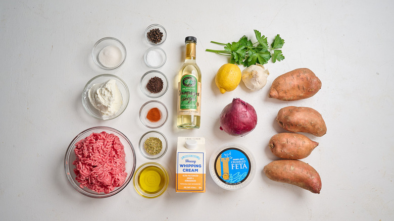 Loaded beef sweet potatoes with whipped feta ingredients on a table