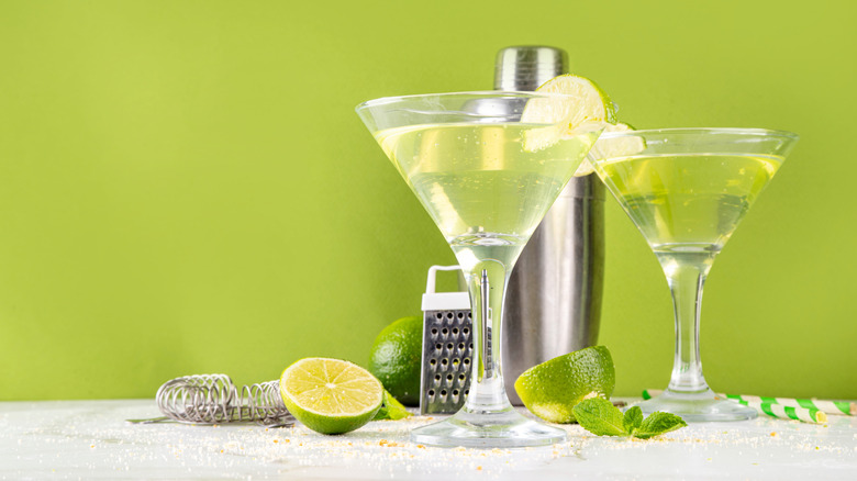martini glasses with fresh limes and a cocktail shaker