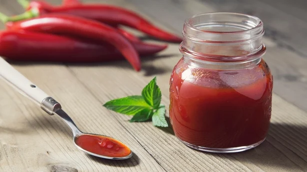 portrait of red chili peppers confiture lying on a teaspoon