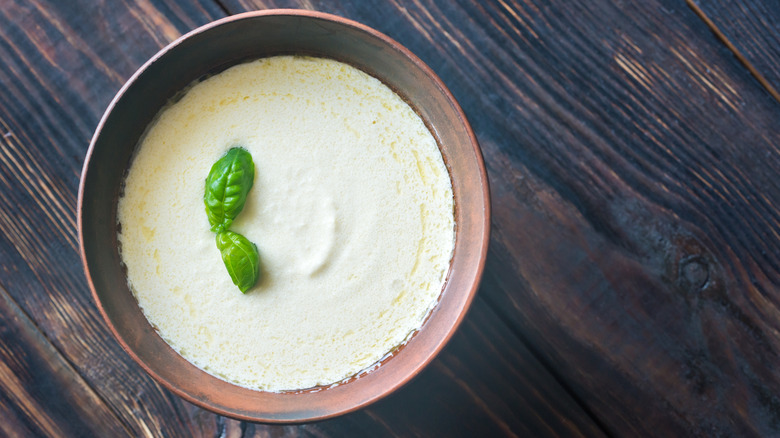 Dish of Alfredo sauce garnished with basil leaves