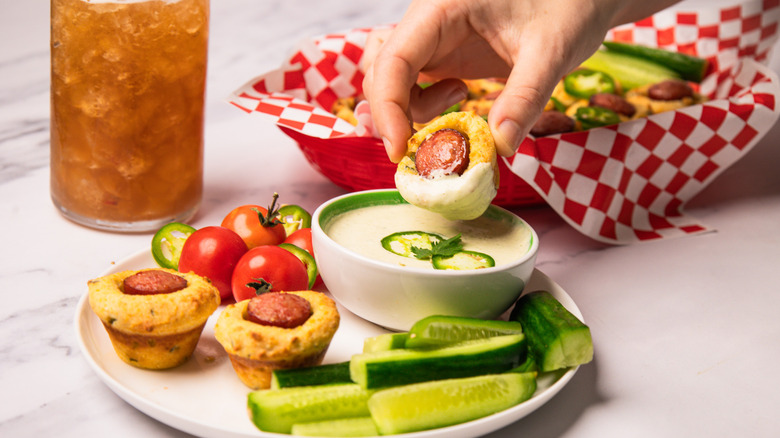 Dipping a corn dog into spicy jalapeno crema.