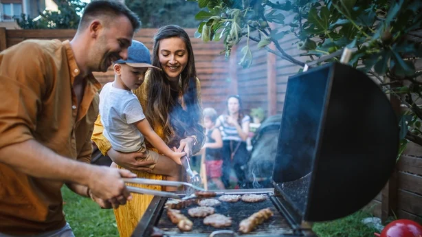 Young happy family having a barbecue party in backyard