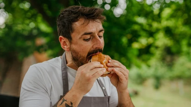 Man relishing the flavor of a homemade BBQ burger