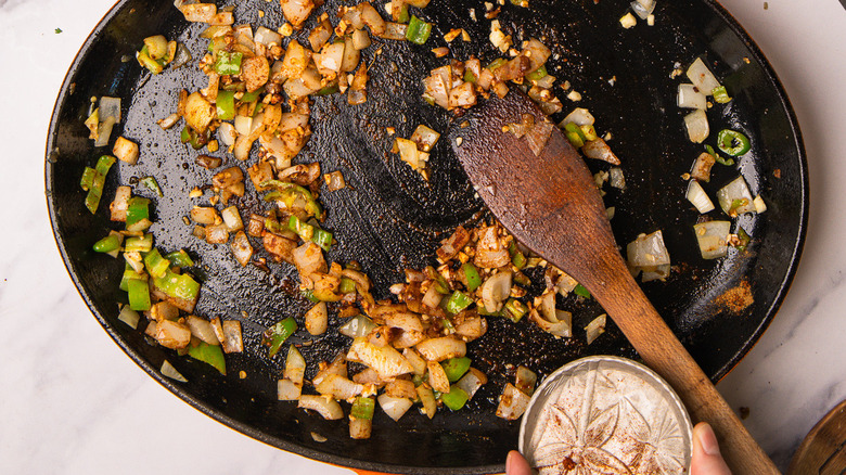 cast iron pan with seasoned onions and peppers