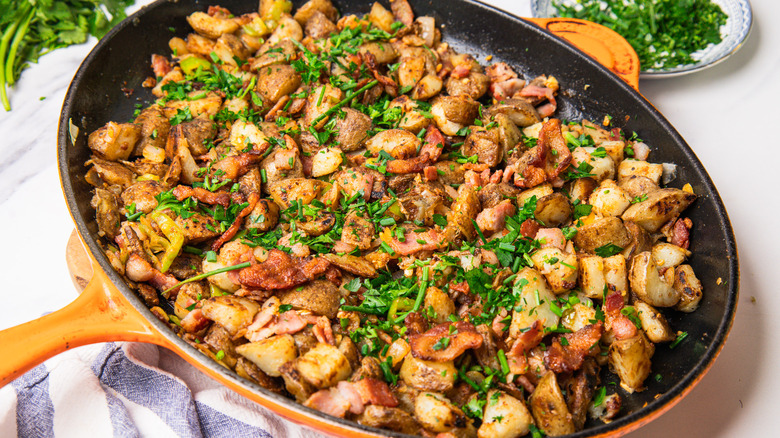 Cowboy-style potatoes in a cast iron pan on a table.