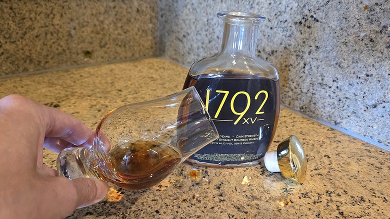 Barton XV bottle with Glencairn glass turned on its side to observe the color