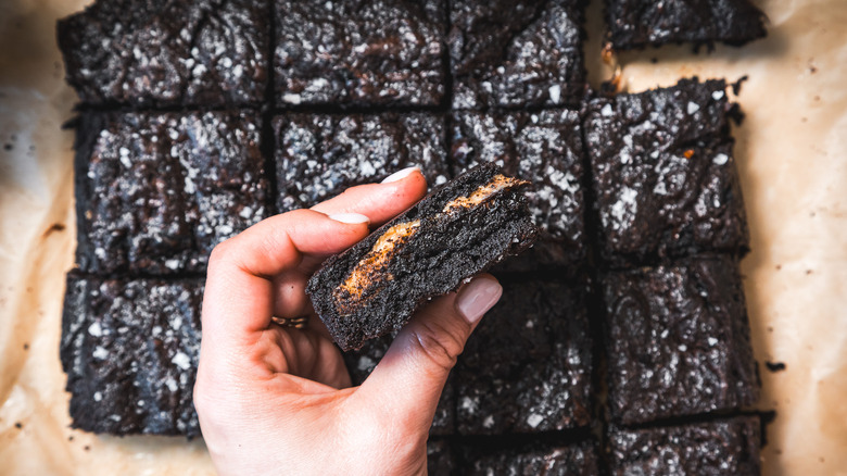 Hand holding one brownie over others.