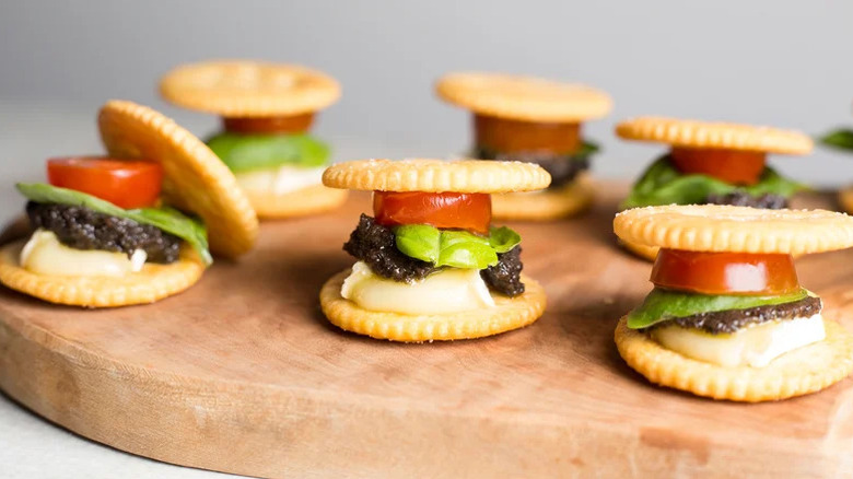 crackers stacked with Brie and tomato