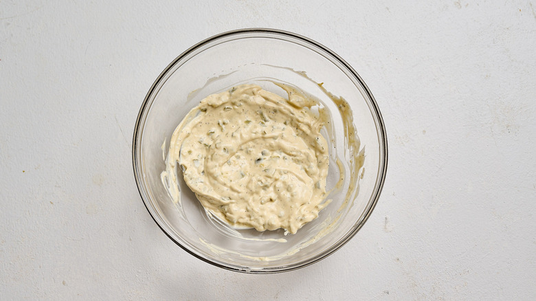 mayonnaise, mustard, and cornichons stirred together in a bowl