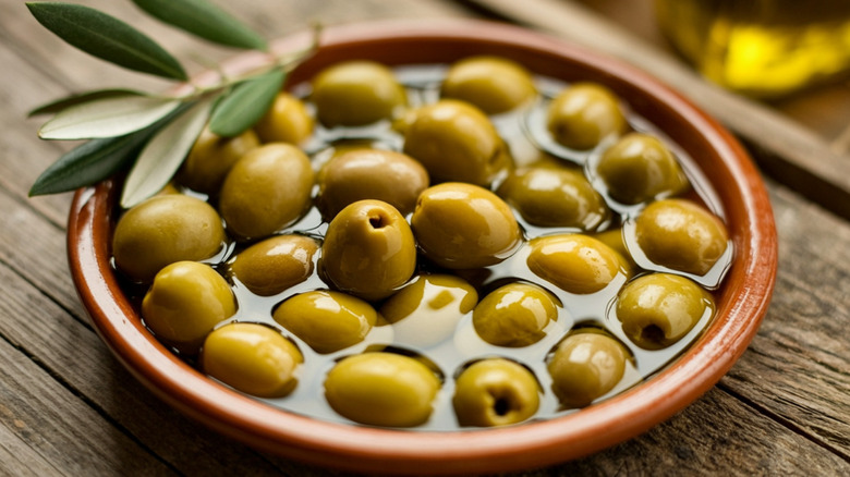 Dish of green olives in oil