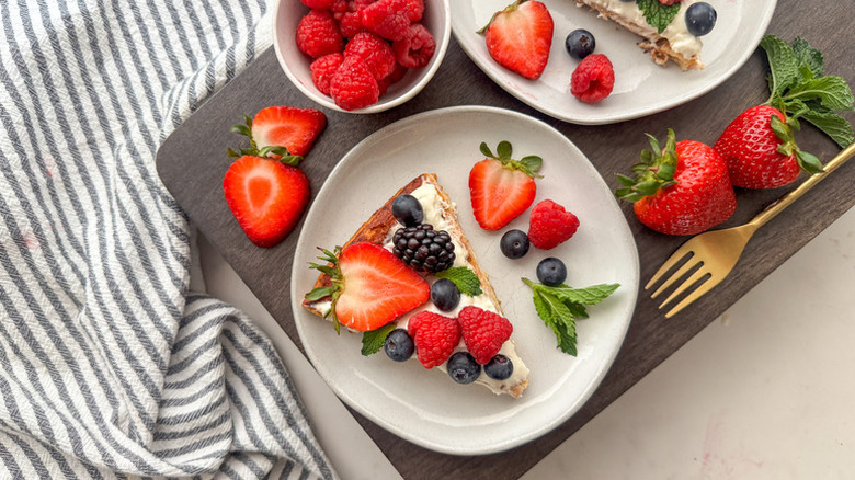 Berry-topped breakfast fruit pizza slices on plates