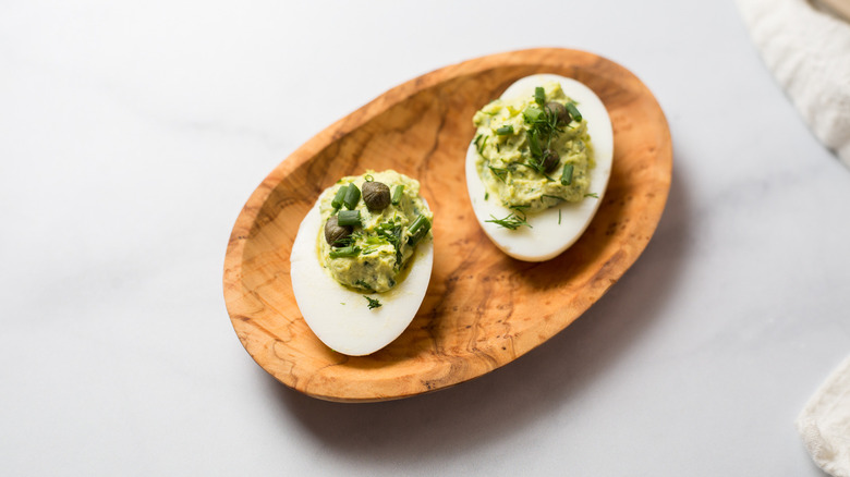 deviled eggs on wooden dish