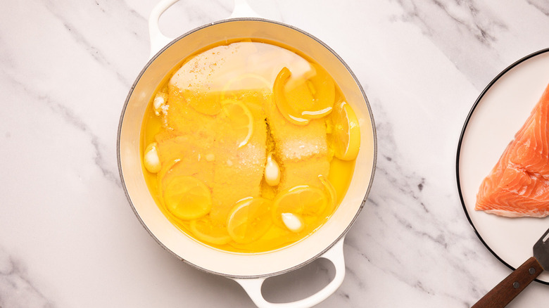 Cooked salmon in poaching oil.