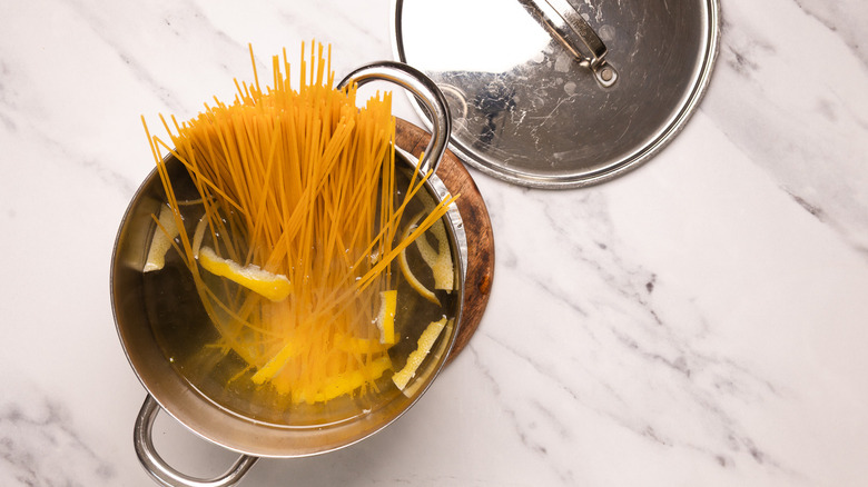 Adding pasta to pot.