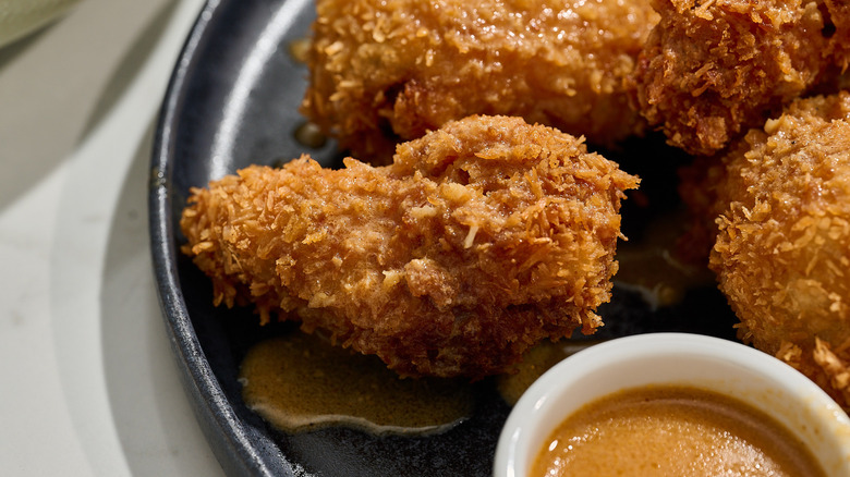 close up of a chicken wing on a plate with sauce