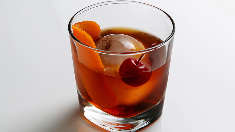 cocktail glass with reposado tequila, orange zest and cherry