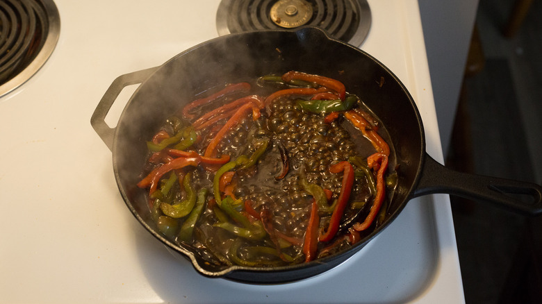 peppers cooking in iron pan