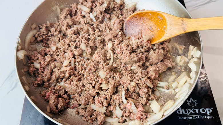 Beef and onions cooking in skillet