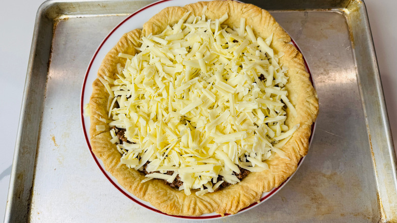 Pie crust topped with shredded cheese