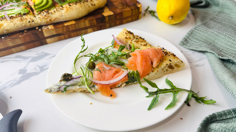 Bagels and lox pizza slice on plate