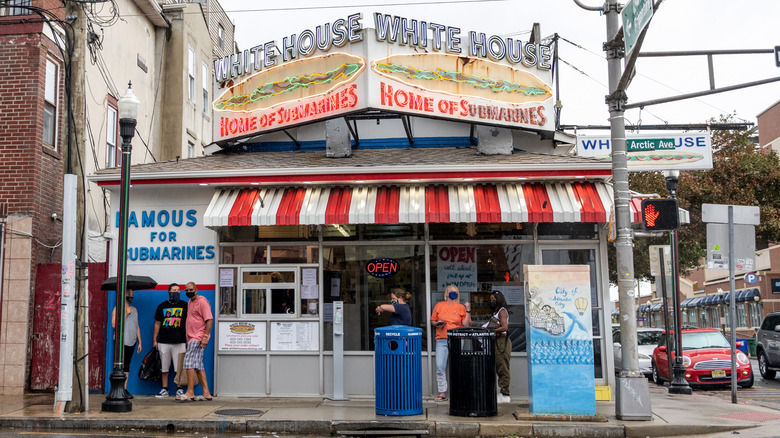 Exterior of White House Subs with customers standing outside
