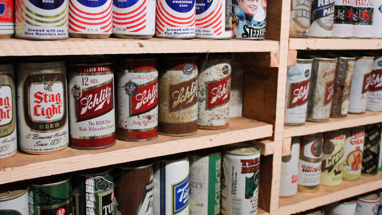 Collection of dusty vintage beer cans including Schlitz