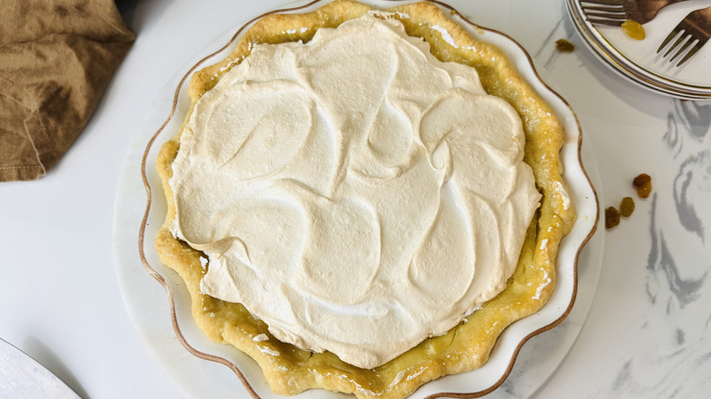Sour cream raisin pie with meringue topping on table