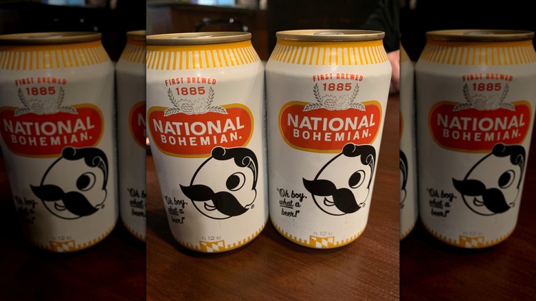 Two cans of Natural Bohemian beer on a wooden table