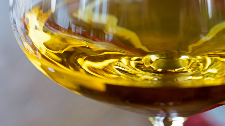 Extreme closeup of a glass of oaked chardonnay, golden in color