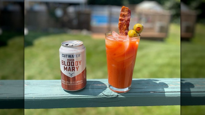 Cutwater Spicy Bloody Mary in can and glass on balcony railing