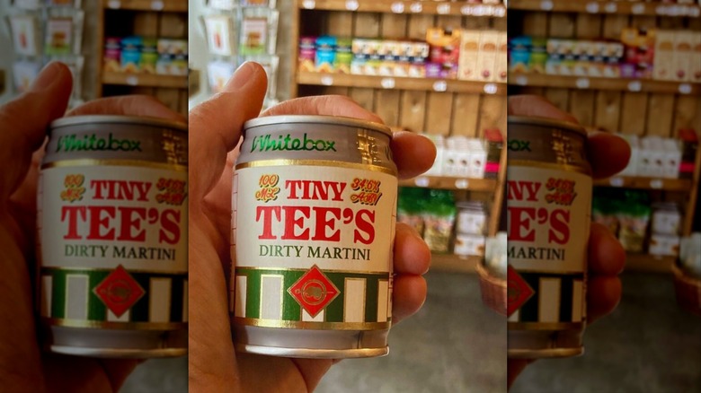 Hand holding can of White Box Tiny Tee's Dirty Martini inside a store