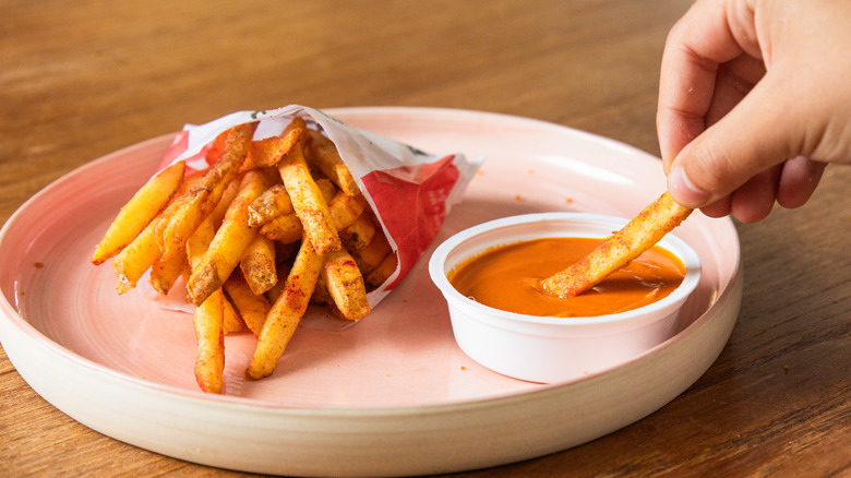 Dipping the Flamin' Hot Fries into the Flamin' Hot Dip Cup