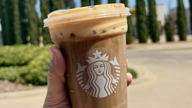 customer holding Starbucks pumpkin cream cold brew coffee
